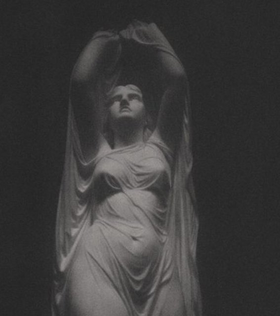 Veiled marble statue of a woman, arms raised